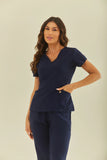 Scrub feminino Julia cor marinho - conjunto blusa e calça cirúrgica, vista de frente com a mão no bolso